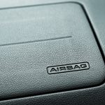 Close-up view of textured car dashboard with airbag label embossed in corner.