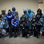 Group of people in Star Wars costumes with two women in matching tracksuits.