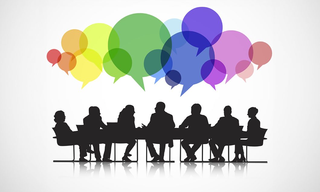 Silhouetted group of people in meeting with colorful speech bubbles above their heads.